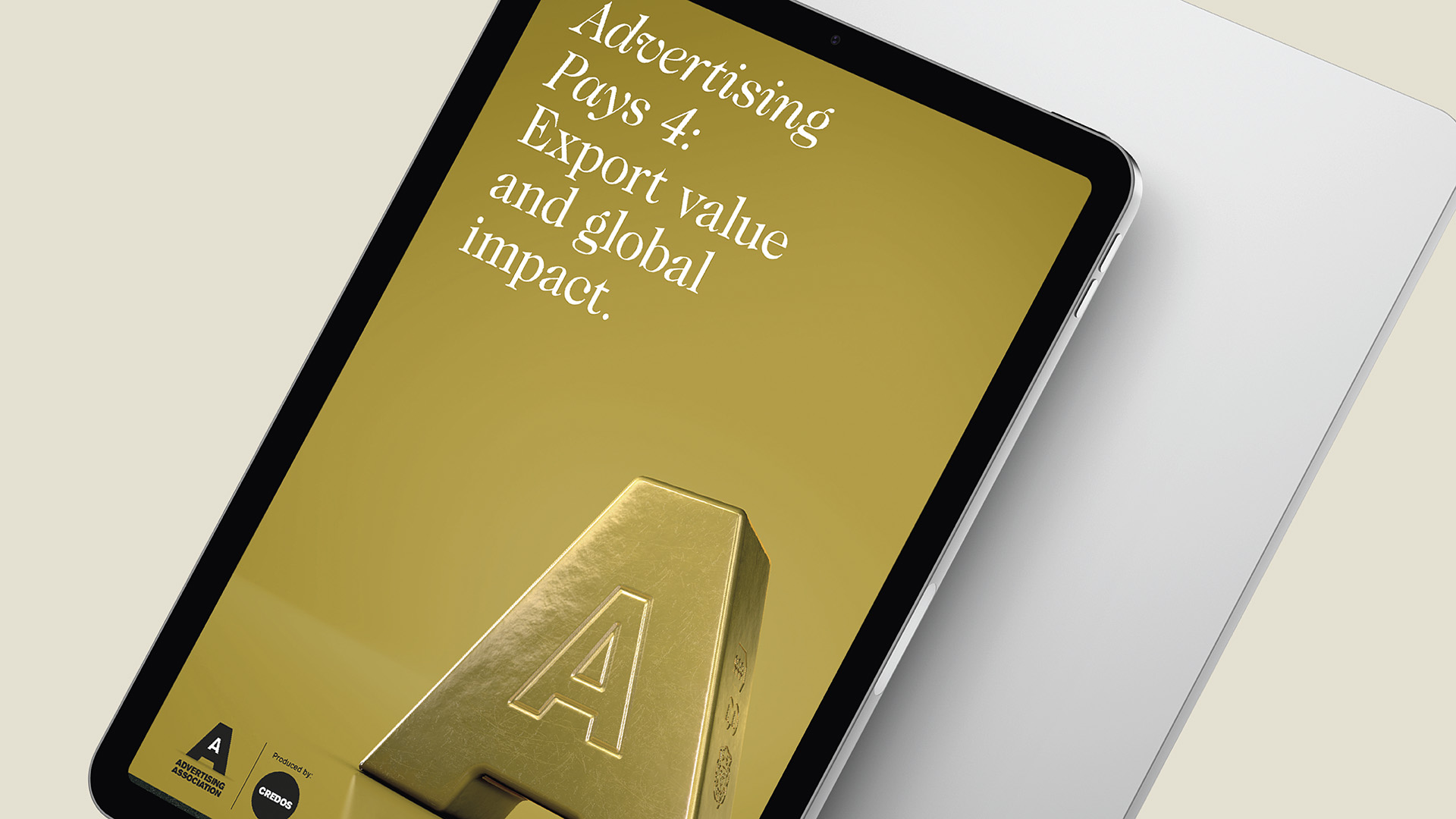 A mobile phone displaying the Advertising Association Ad Pays Report Cover with gold background and a three dimensional solid 'A' block with logos