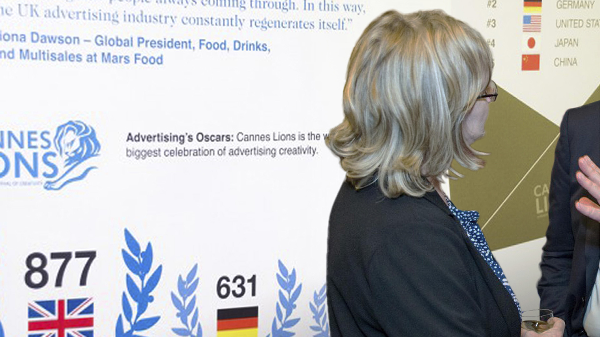 An image of the Advertising Association Ad Pays Report Parliament Event Banner on a wall with two people talking in front of it.