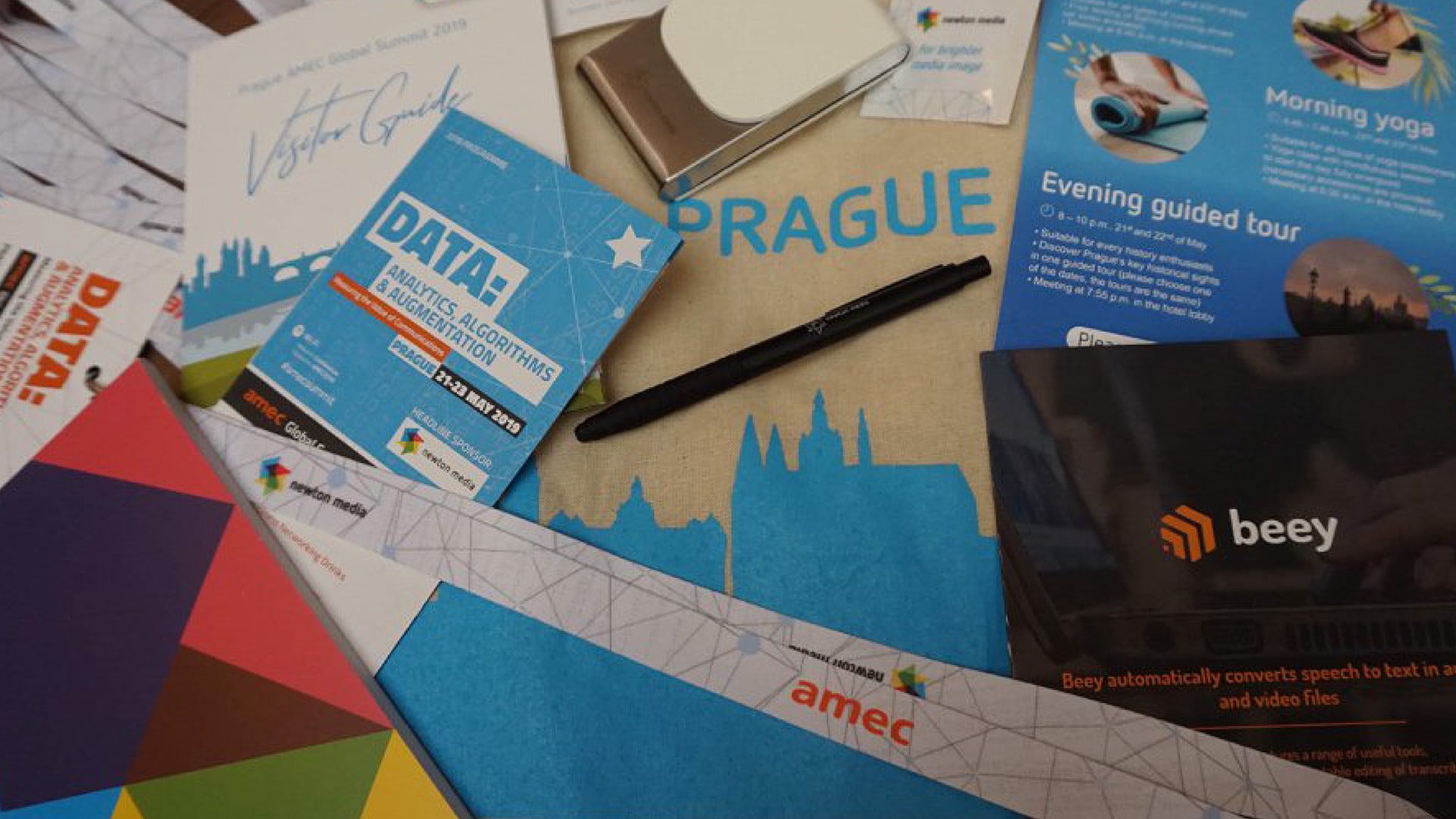 A close-up photo of a selection of brochures and flyers for Association for the Measurement and Evaluation of Communication AMEC Global Summit Event Pack
