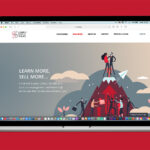 A laptop displaying the London School of Sales LSOS Website Homepage on a bright red background