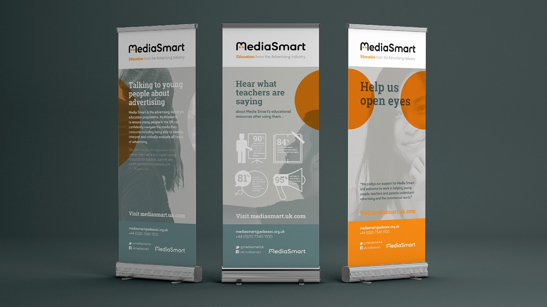 A photograph of three MediaSmart Event Roller Banners displayed in a line with a grey background.