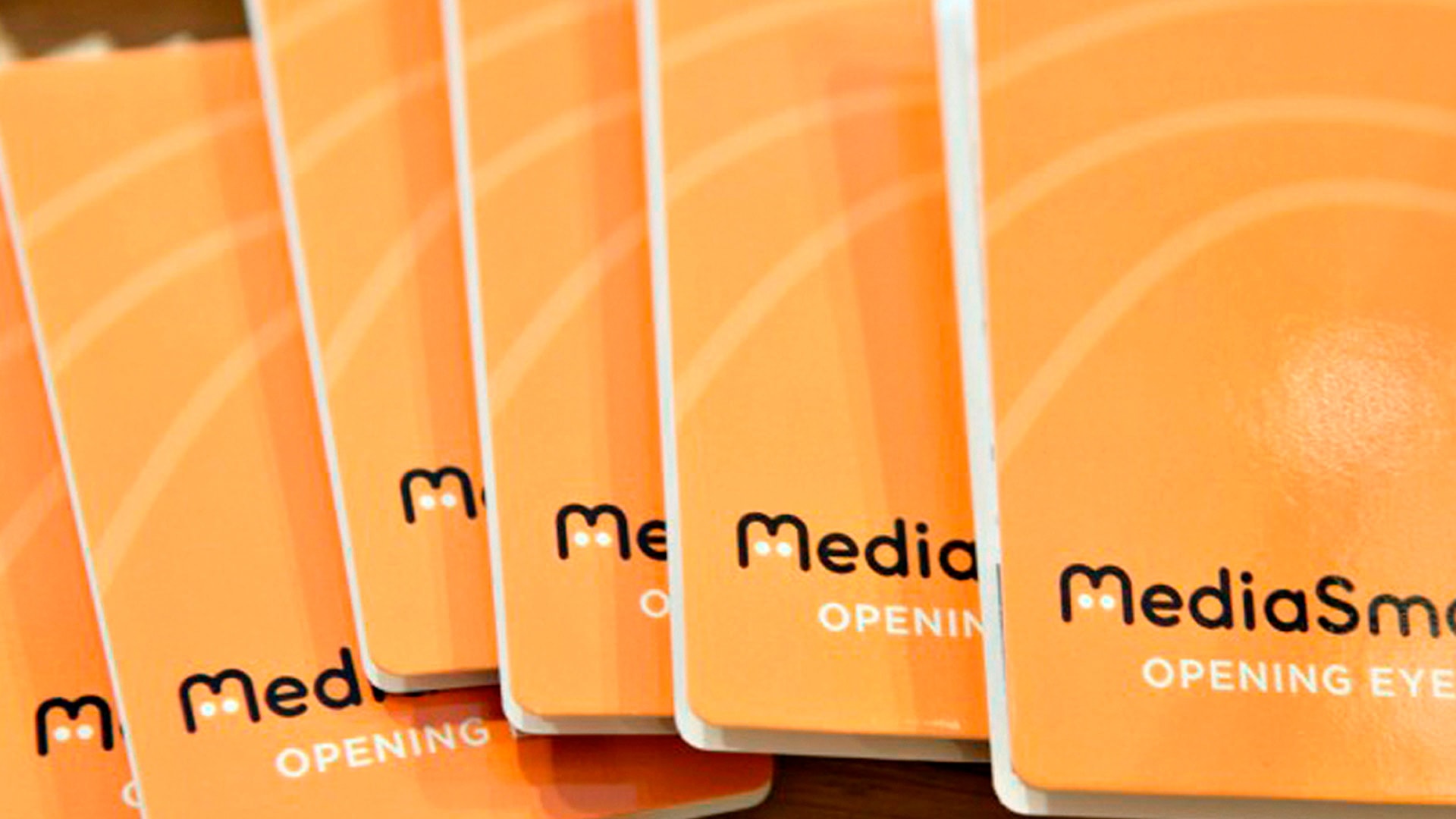 A stack of orange MediaSmart Zcard Brochure Covers