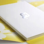 A Mintel Loop white book cover with silver logo and yellow outer packaging on a white surface