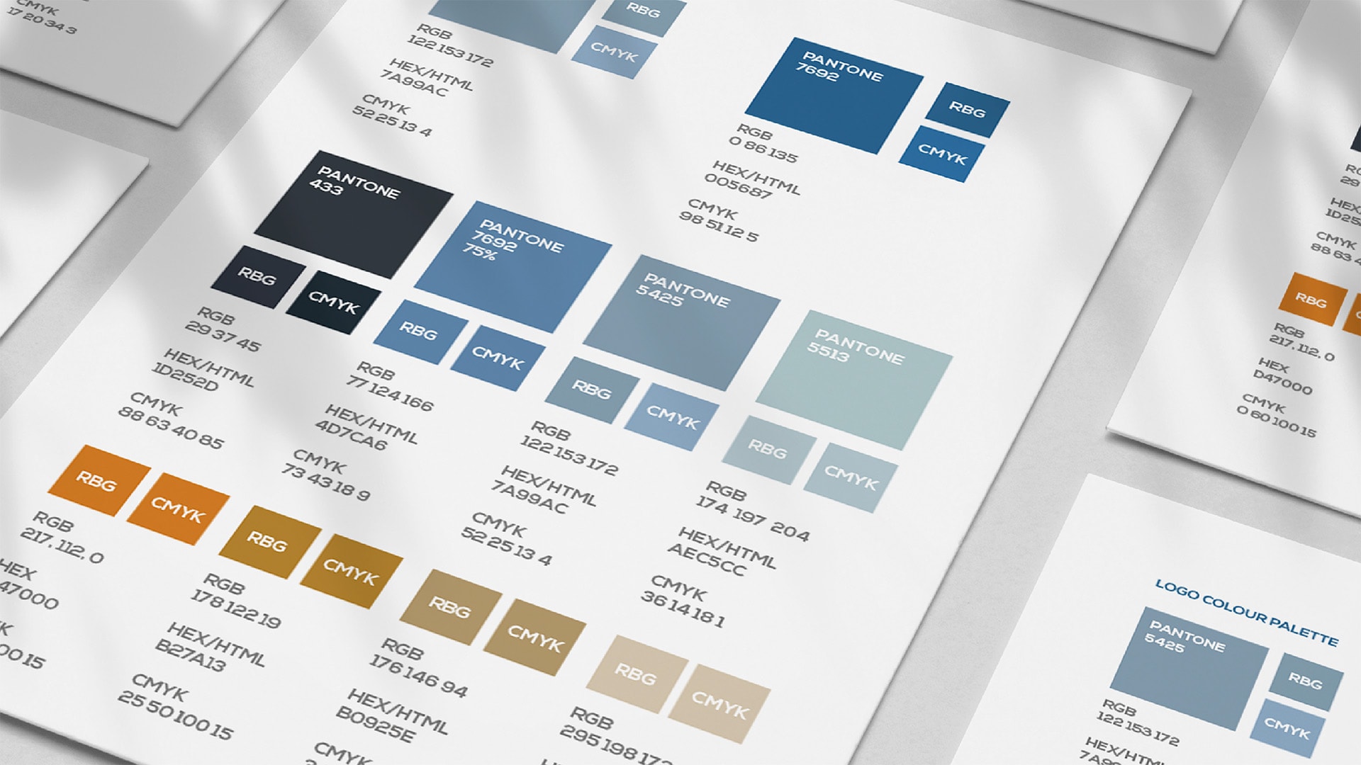 A close-up display of the Seascope Maritime Insurance Brand Guidelines on A4 pieces of card with colourful Pantone charts.