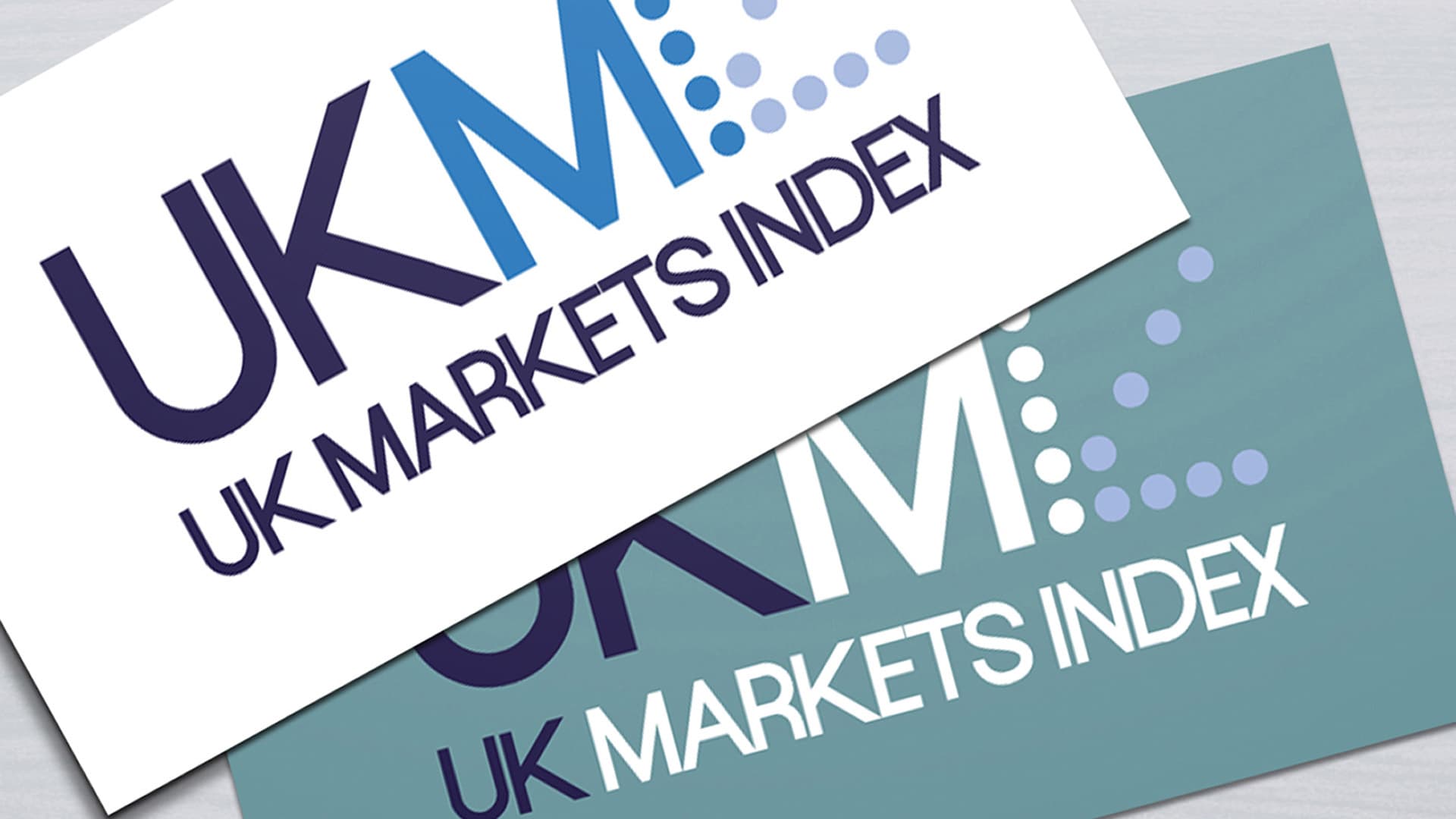 A close-up image of two UK Markets Index business cards with logo